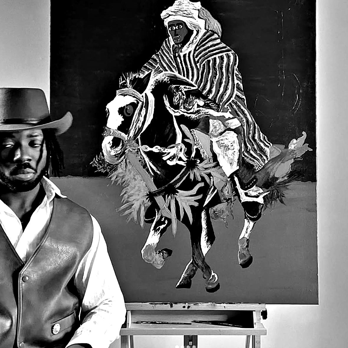 Portrait of figurative painter Akintunde Durodola beside one of his paintings