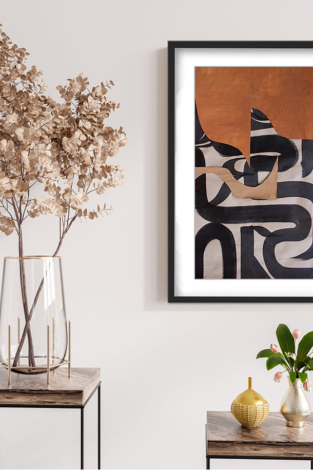 Modern abstract framed wall art in earthy tones and black accents, styled in a minimalist room.