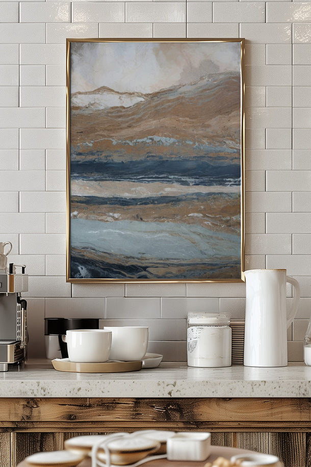Modern abstract landscape wall art with earthy blue and gold tones in a thin gold frame, styled above a rustic wooden kitchen counter with white subway tile by Ready2hangart.